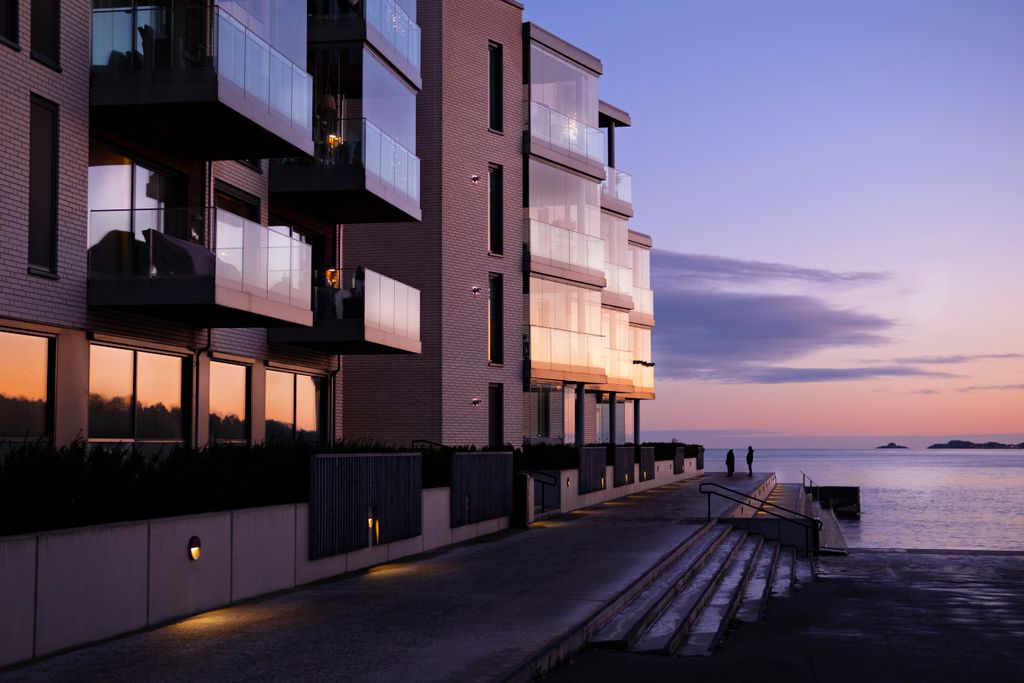 Contemporary apartment building overlooking the seacoast at sunset, capturing a serene evening ambiance.